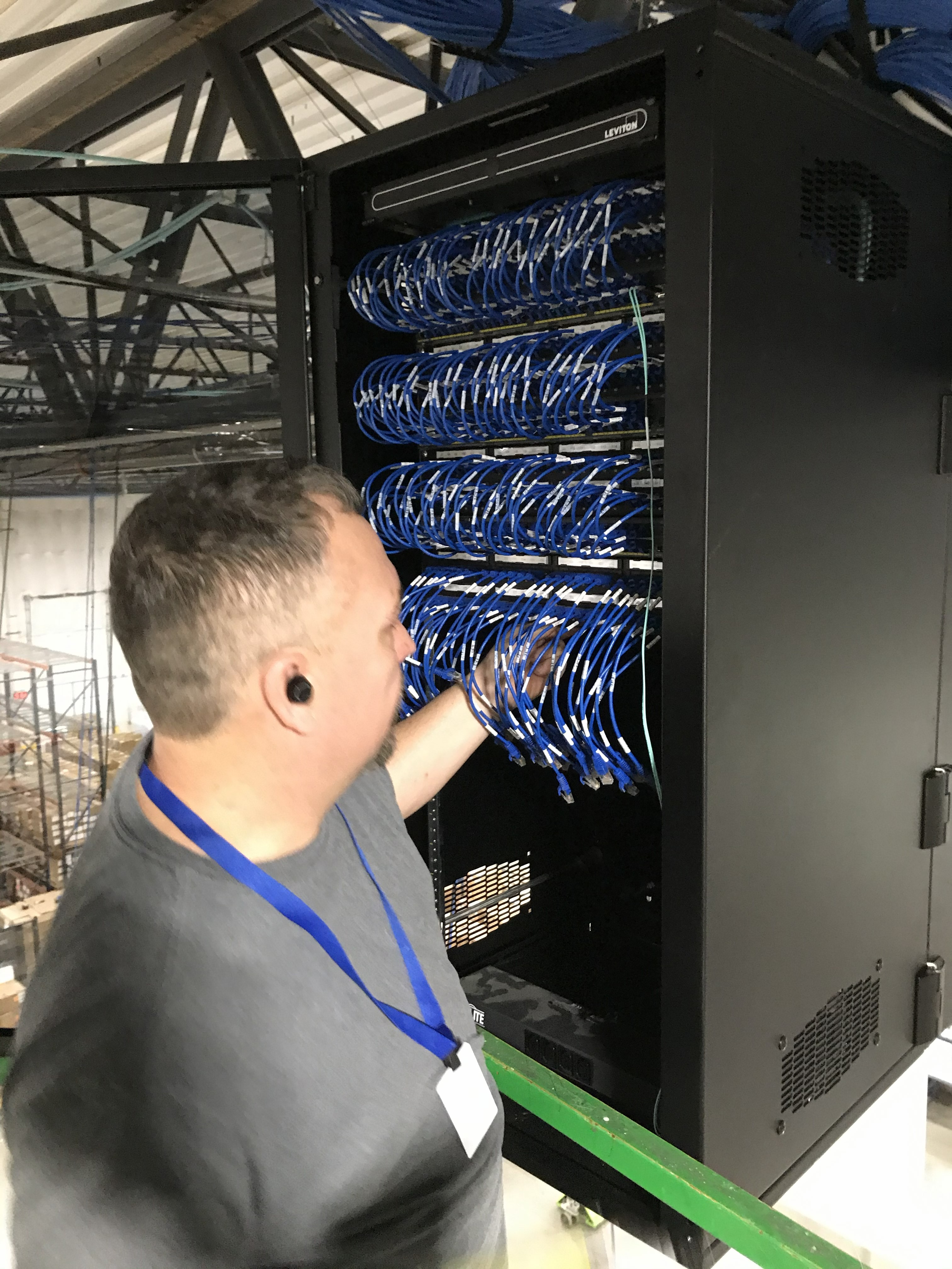 Technician working inside a network cabinet